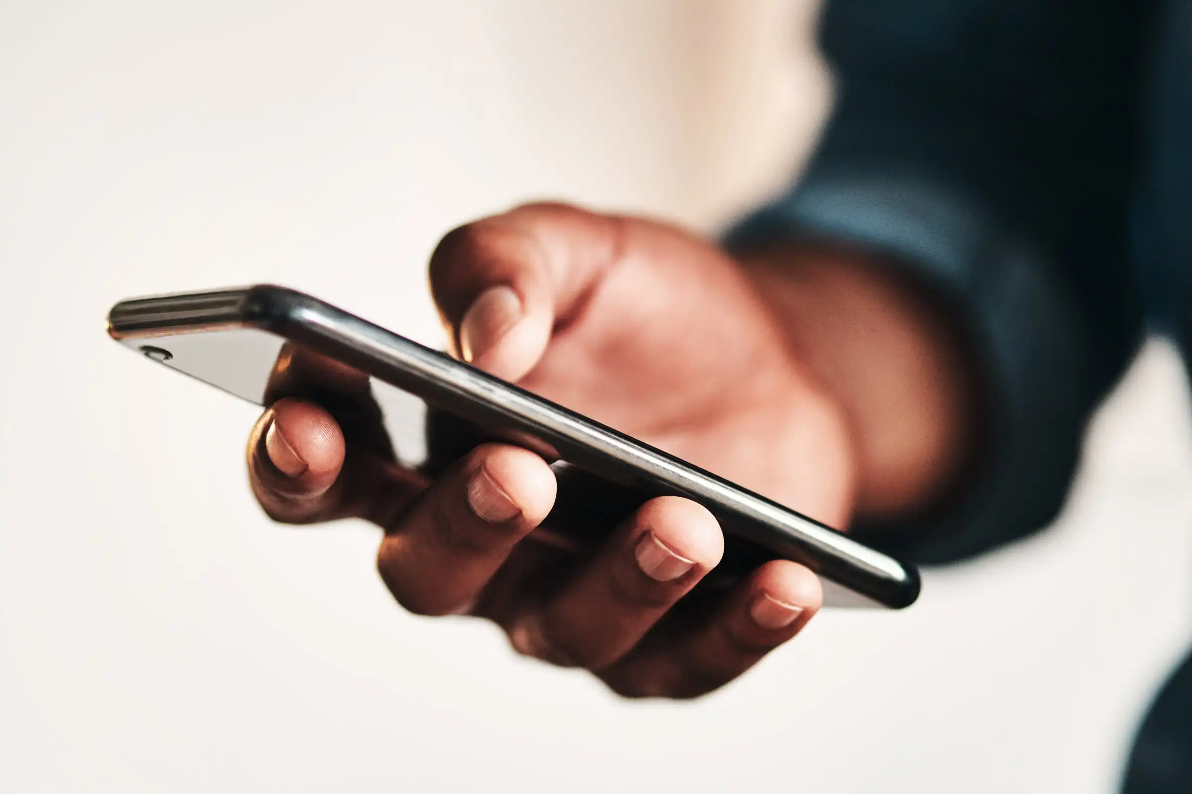 diversity_south-africa_man-holding-smartphone_mobile-technology_connected_by-peopleimages-gettyimages-1187582529-100850370-orig